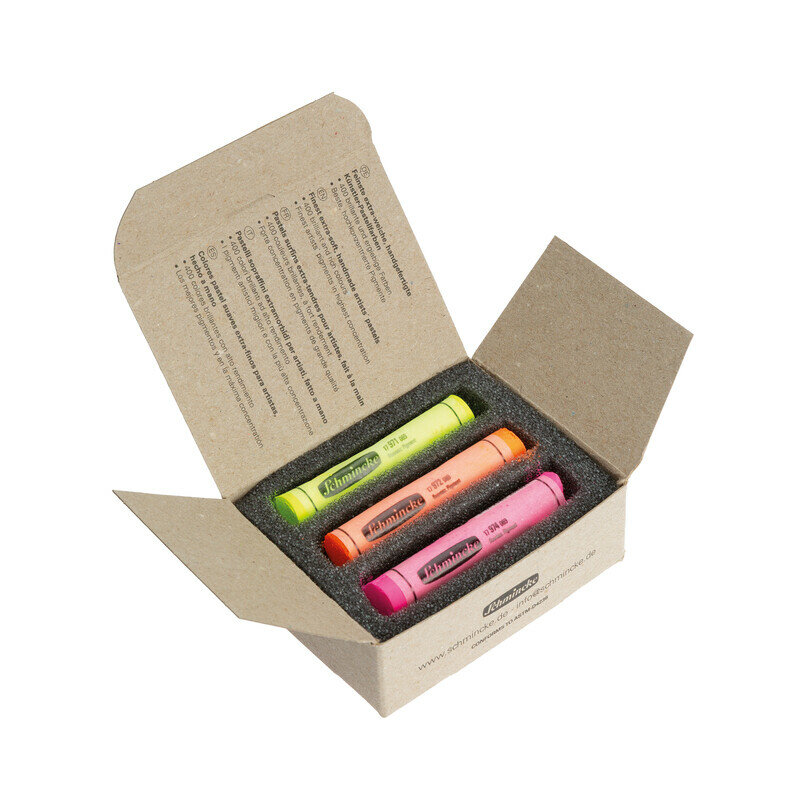 Geopende kartonnen Schmincke verpakking. Binnenin liggen drie handgemaakte zachte pastels veilig in een donkergrijze schuiminla