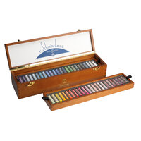 Hoekopname van de geopende Schmincke retro kist. De bovenste houten inlay met pastels is uit de kist getild, waardoor de onders