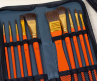 Close-up van het geopende zwarte Kangaro etui. De 10 oranje penselen in verschillende diktes en vormen worden veilig en overzic